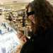 Una ragazza intenta a scegliere il tester di un rossetto in profumeria. Il tester  una confezione del cosmetico messa a disposizione del cliente per una prova